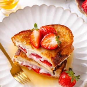 Plate of strawberry and cream cheese French toast with maple syrup.
