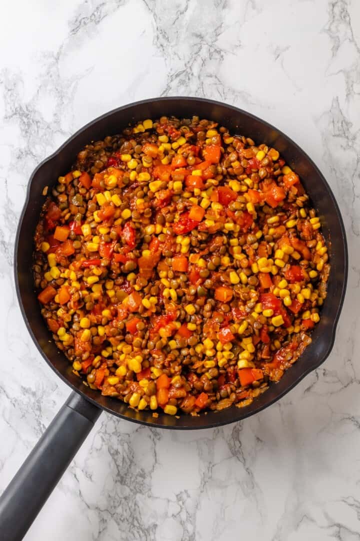 Skillet with lentil and veggie filling for tamale casserole.
