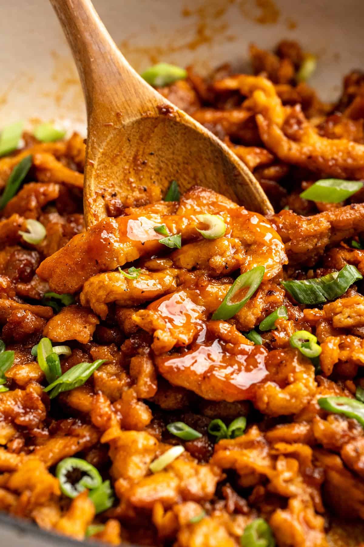 A little bit crispy, budget-friendly and packed with bold flavour, these BBQ soy curls are an easy vegan staple you’ll make again and again! Stirring BBQ soy curls in pan with wooden spoon.