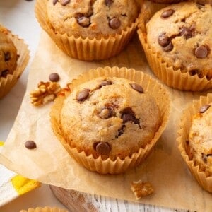 Vegan banana chocolate chip muffins on wooden board.