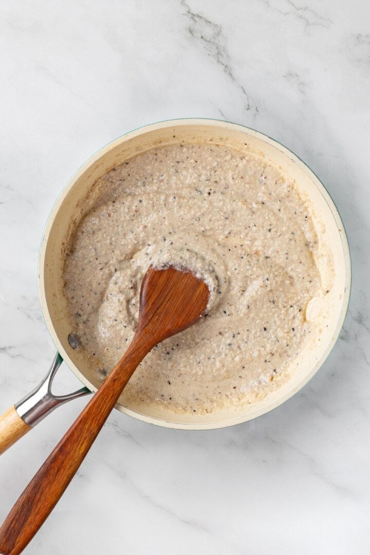 Creamy cacio e pepe sauce in skillet.