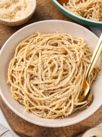 Bowl of cacio e pepe with fork and spoon.