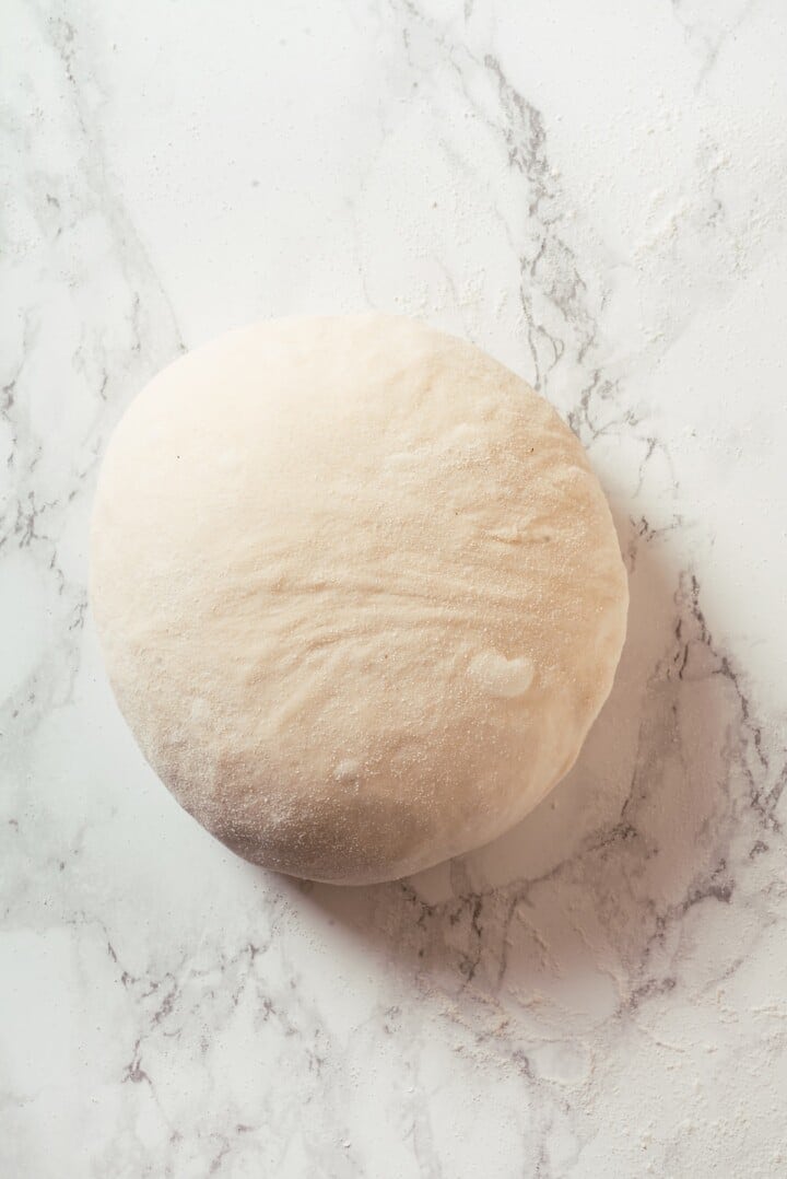 This Dutch oven sourdough bread gives you a bakery-style loaf with a crisp, golden crust and chewy interior. It's easier than you think! Shaped sourdough loaf.