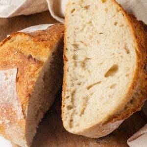 Loaf of Dutch oven sourdough bread sliced in half to show interior.