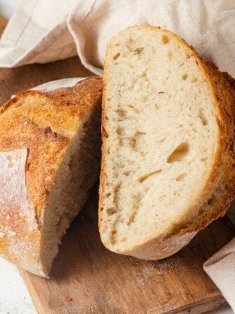 Loaf of Dutch oven sourdough bread sliced in half to show interior.