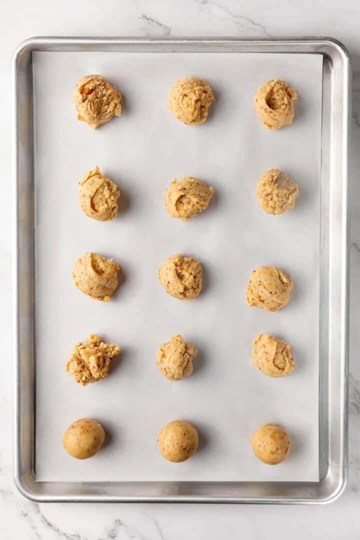 Buttery, melt-in-your-mouth and coated in powdered sugar, these vegan Mexican wedding cookies have everything you love about the original! Mexican wedding cookie dough scooped onto baking sheet.