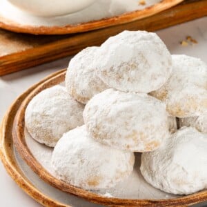 Mexican wedding cookies stacked on plate.