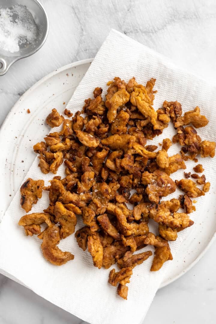 Soy curl "chicken" is a budget-friendly vegan swap for chicken that's crispy on the outside, full of savoury flavour, and super versatile! Soy curl chicken on paper towel.