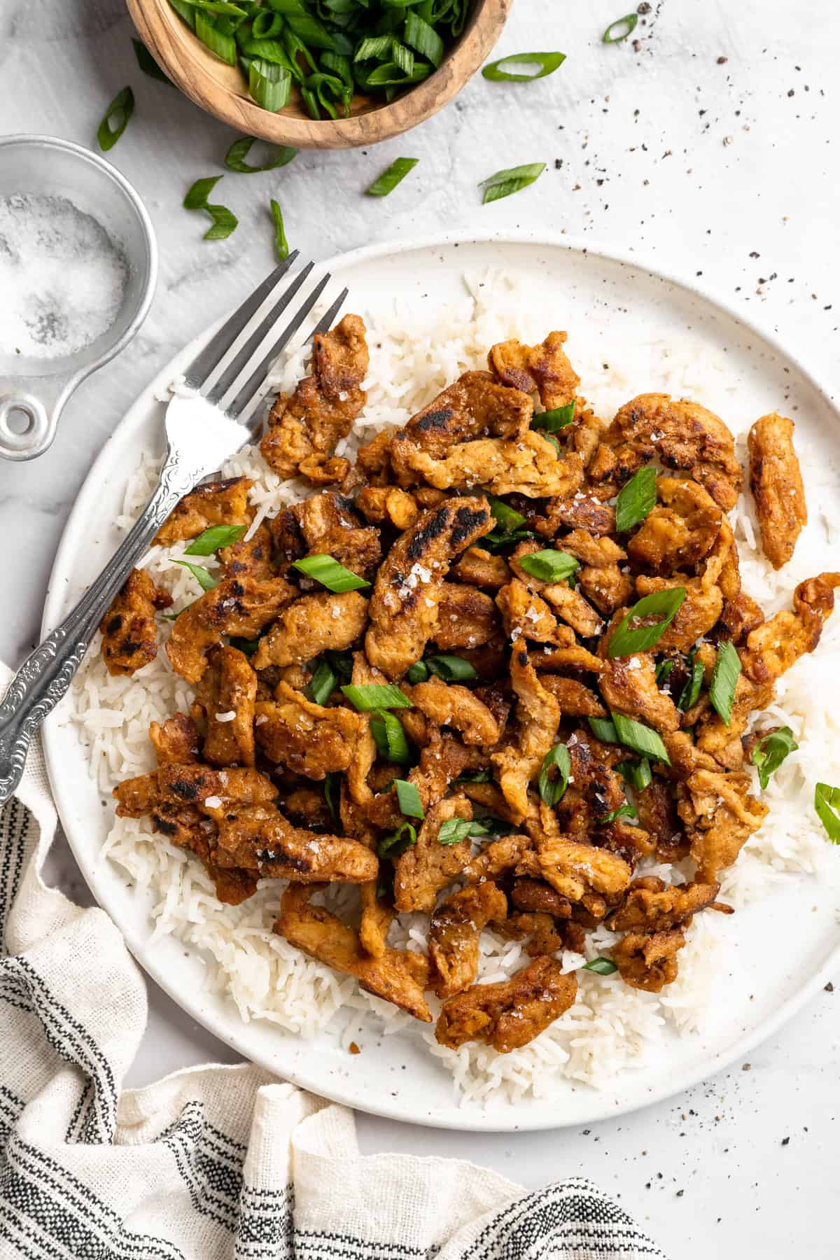 Soy curl "chicken" is a budget-friendly vegan swap for chicken that's crispy on the outside, full of savoury flavour, and super versatile! Soy curl chicken served on plate of rice.