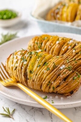Two hasselback potatoes on plate.