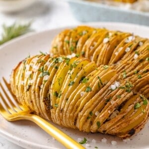 Two hasselback potatoes on plate.
