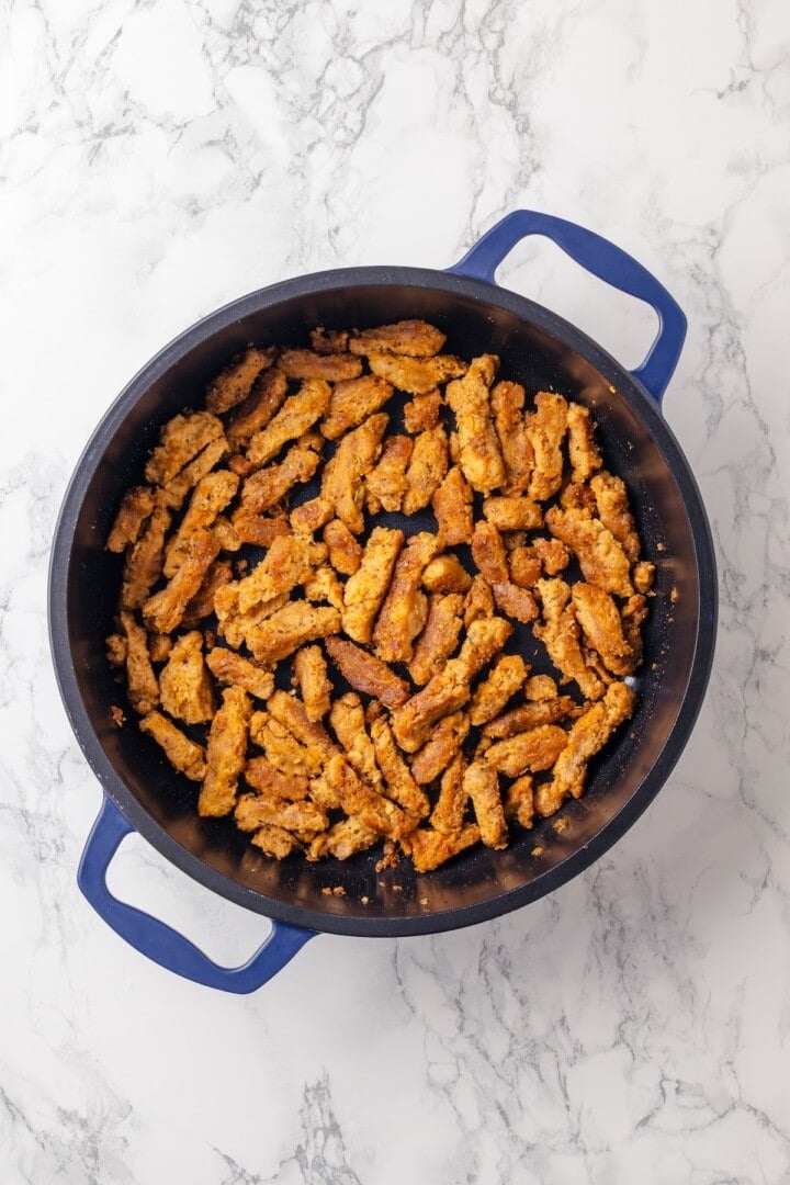 This vegan “chicken” Alfredo recipe is made with budget-friendly soy curls to replace the meat. It’s rich, garlicky and creamy. So good! Vegan soy curls in pan.