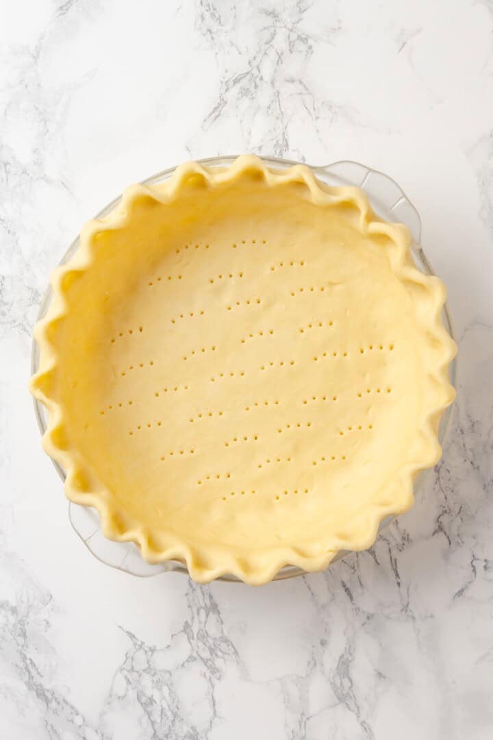 Pie crust pierced with fork before baking.