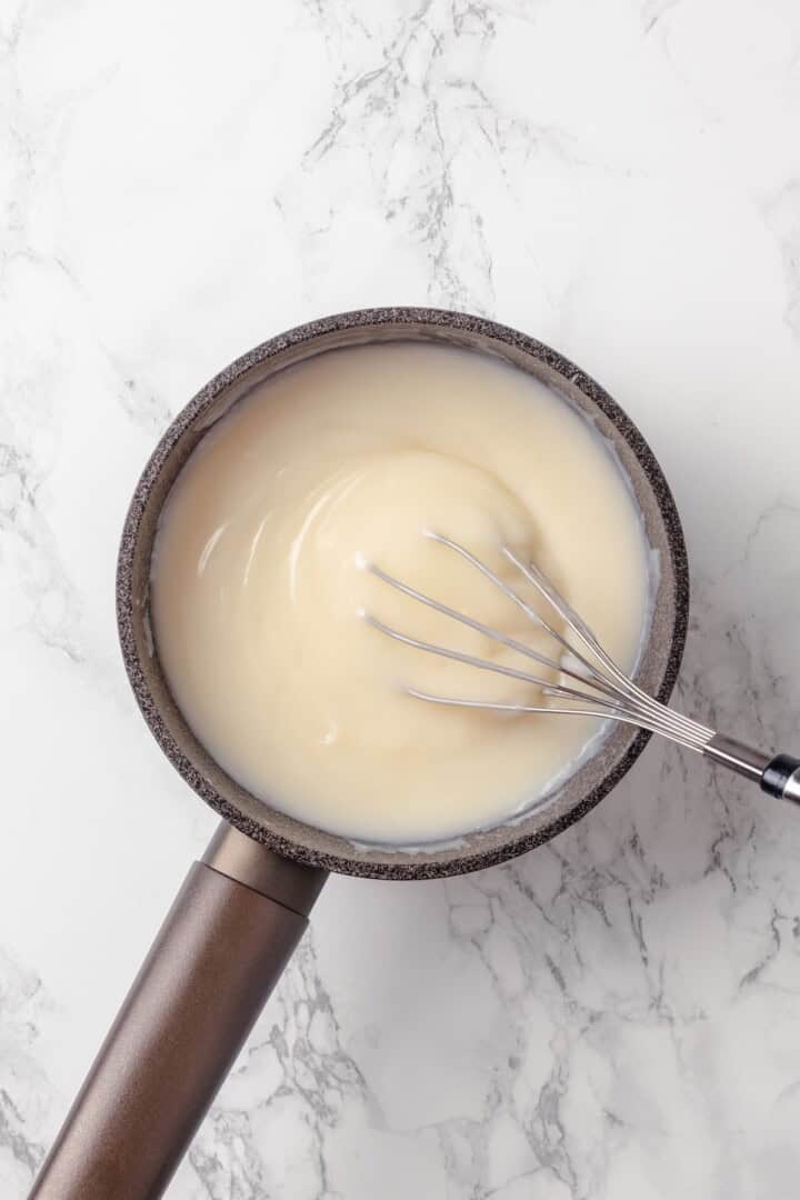 Custard filling in pan with whisk.
