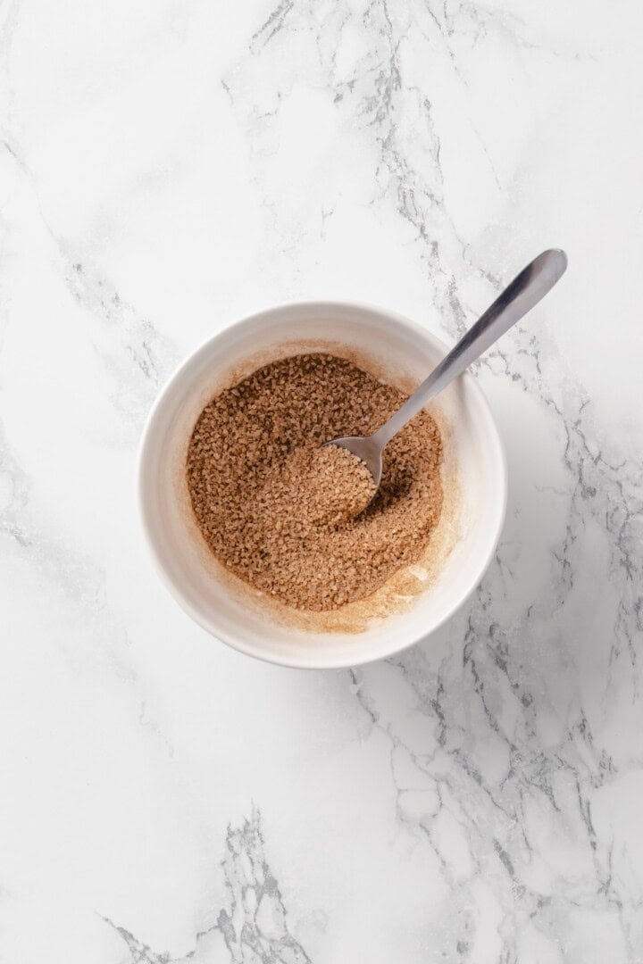 Cinnamon sugar mixture in bowl with spoon.
