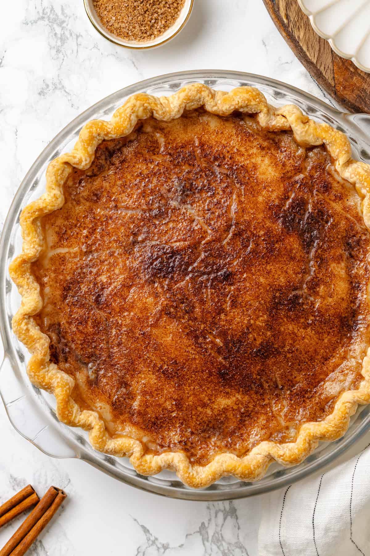Whole sugar cream pie in glass pie plate.