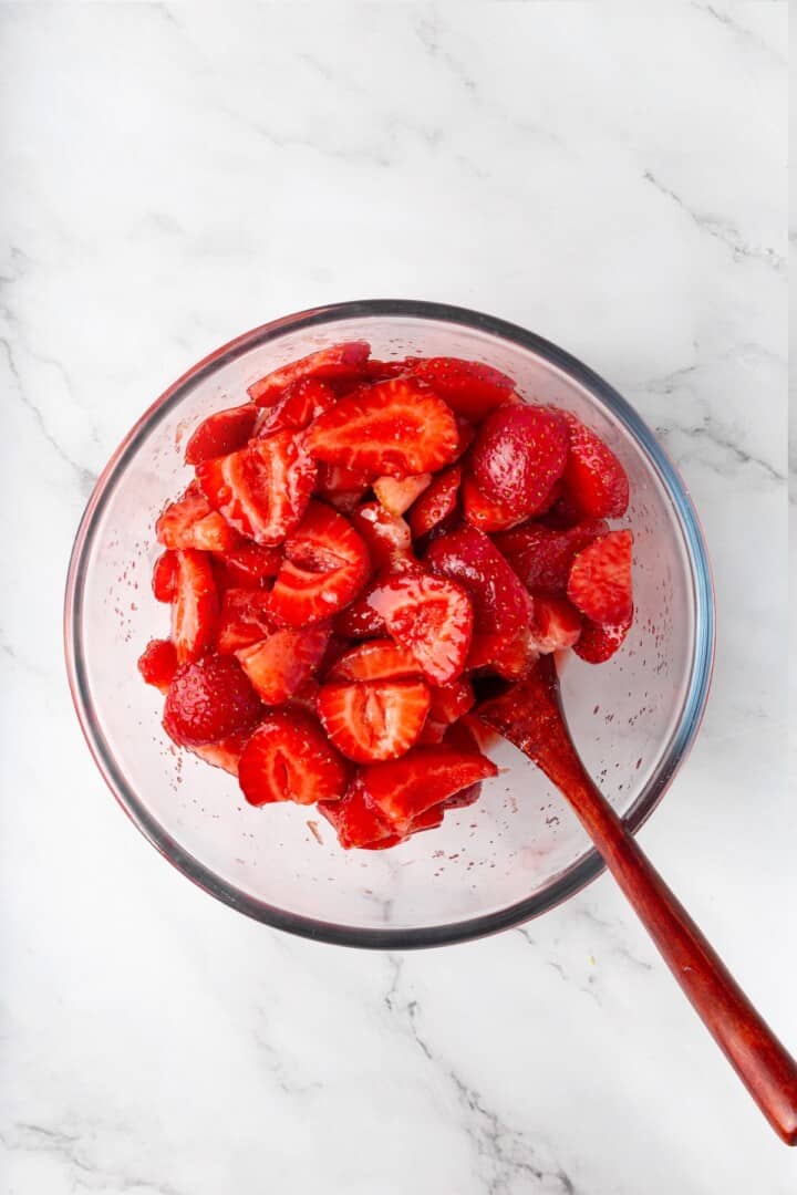 These beautifully simple macerated strawberries are so sweet and syrupy. They're a perfect addition to the breakfast OR dessert table. Mixing together sliced strawberries, sugar, lemon juice, lemon zest, vanilla, and a little salt.