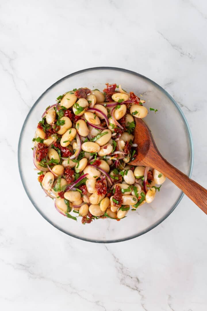 These easy marinated beans are soaked in a bright lemon-Dijon marinade with fresh herbs and aromatics. The perfect summer side. Tossing white beans, sun-dried tomatoes, and red onions in a marinade with fresh herbs.