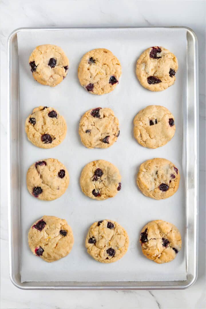 Loaded with jammy pockets of fresh berries and topped with a sweet lemon glaze, these vegan blueberry cookies are a summer must. Blueberry cookies on a cookie sheet.
