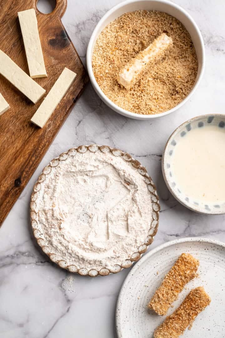 This tofu salad, topped with Cajun fried tofu and creamy, tangy-sweet dressing, is just as good as TGI Friday's version. And it's vegan! Coating a tofu stick in Cajun-seasoned panko.