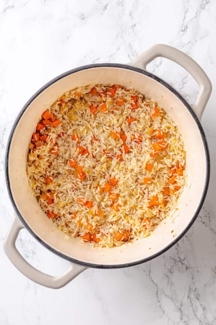 This vegan "chicken" and rice delivers all the cozy, savoury goodness of the meat-eater's version, no chicken required. Toasting rice in a Dutch oven with sautéed onion, carrot, and garlic.