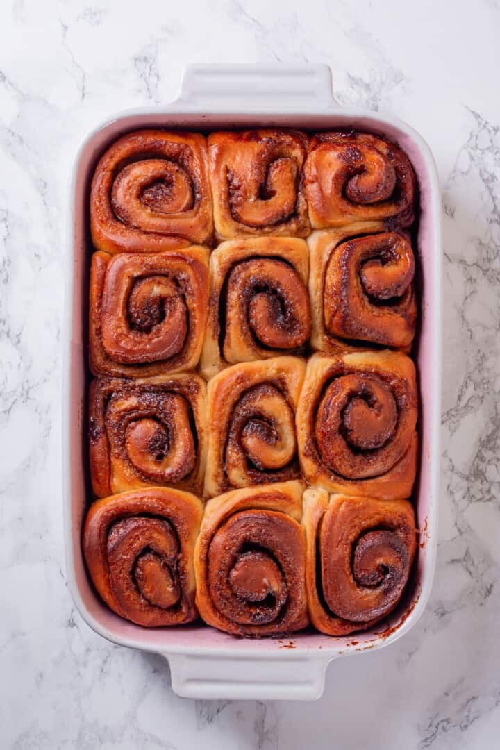 These vegan sourdough cinnamon rolls are impossibly soft, packed with cinnamon sugar filling, and topped with a smooth cream cheese glaze. A pan full of unglazed vegan sourdough cinnamon buns.