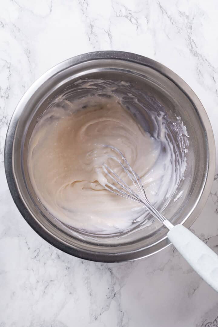 These vegan sourdough cinnamon rolls are impossibly soft, packed with cinnamon sugar filling, and topped with a smooth cream cheese glaze. Whisking together vegan cream cheese, powdered sugar, vanilla, and vegan butter.