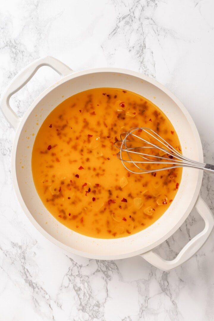 This easy aglio e olio features al dente spaghetti coated in a velvety garlic-infused sauce with a touch of heat from red pepper flakes. Whisking starchy pasta water into olive oil infused with garlic and red pepper flakes.