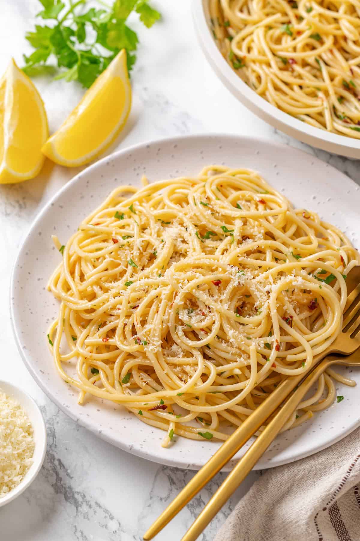 This easy aglio e olio features al dente spaghetti coated in a velvety garlic-infused sauce with a touch of heat from red pepper flakes. A serving of spaghetti aglio e olio on a plate.