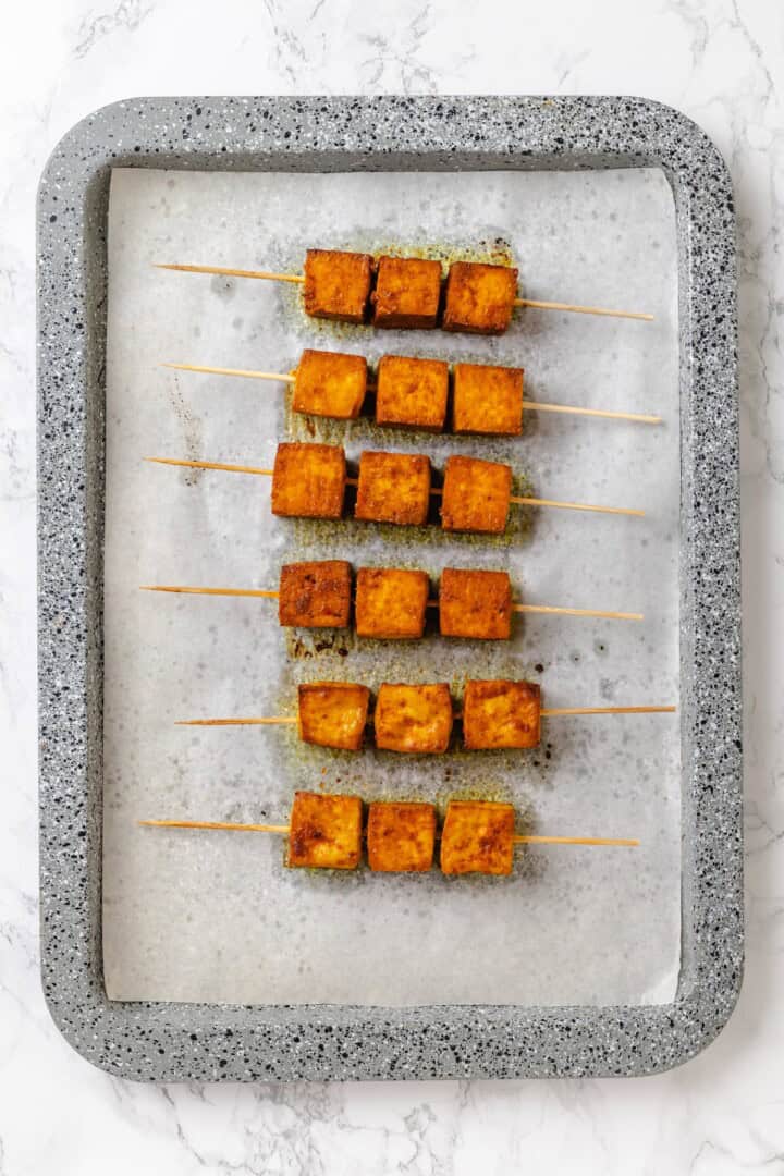 Move over, chicken satay. This tofu satay delivers all the sweet, savoury, tang you crave, with firm caramelised tofu and Thai peanut sauce. Tofu satay on a baking sheet.