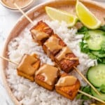 Tofu satay served with jasmine rice, cucumber, lime, and cilantro.