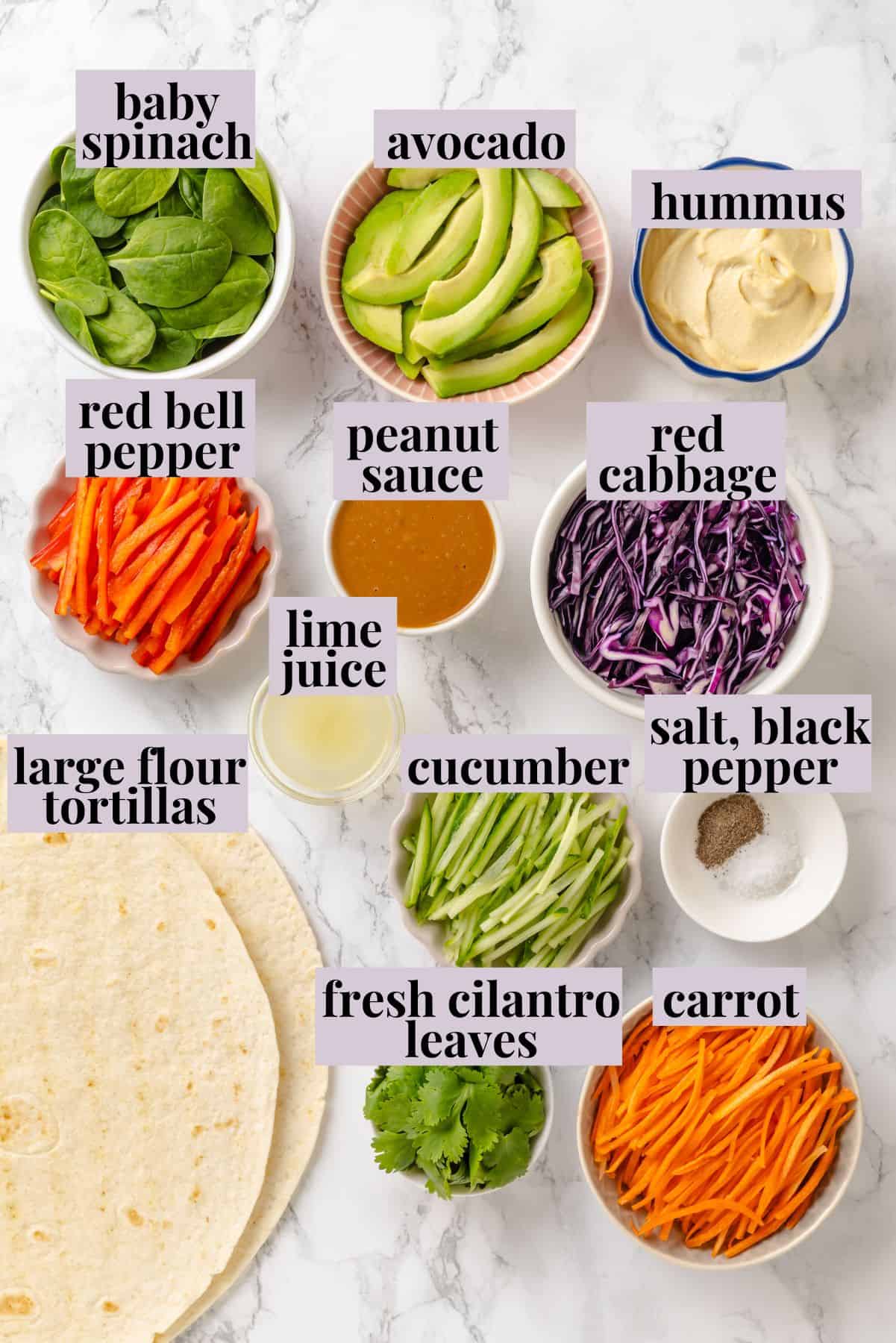 These 20 minute no-cook veggie wraps are packed with creamy hummus and avocado, crisp veggies, bright lime, and a drizzle of peanut sauce. Labeled ingredients for veggies wrap recipe.