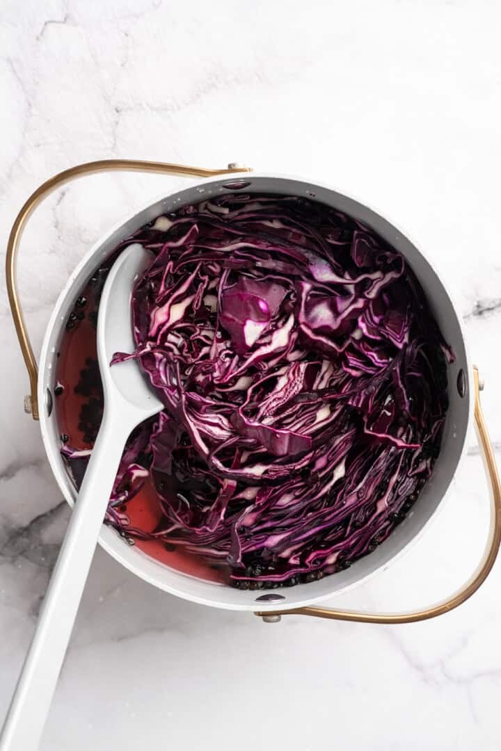 Adding chopped red cabbage to boiling pickling liquid.