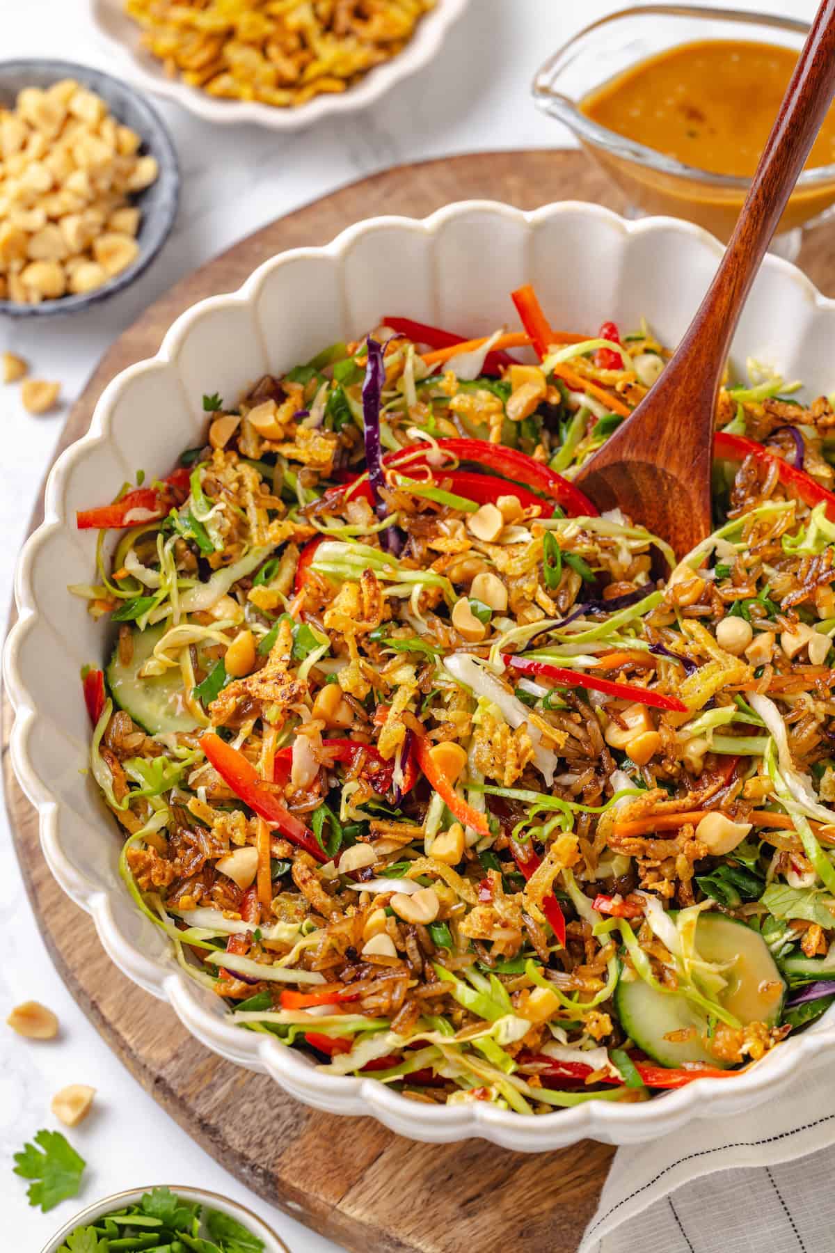 This crispy rice salad is made with soy-infused baked rice tossed with crunchy veggies, caramelized roasted tofu, and Thai peanut sauce. A serving bowl of crispy rice salad with peanut sauce.