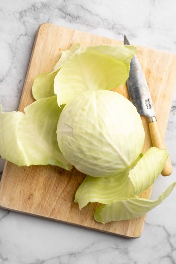 This Jamaican steamed cabbage recipe uses simple cooking methods and simple ingredients to infuse veggies with sweet, savoury island flavour. Pealing back outer layers of cabbage.