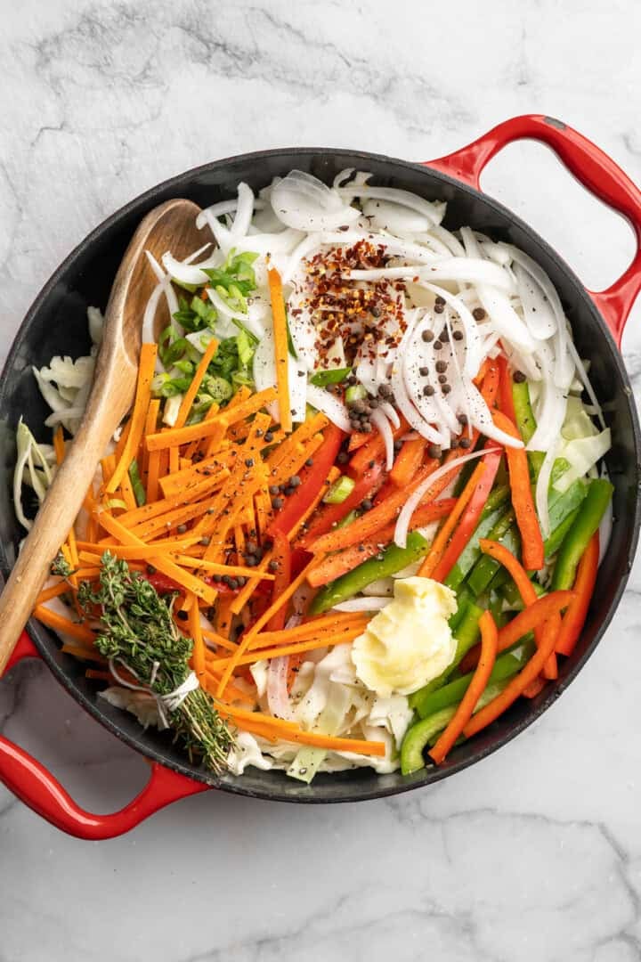 This Jamaican steamed cabbage recipe uses simple cooking methods and simple ingredients to infuse veggies with sweet, savoury island flavour. A Dutch oven full of cabbage, veggies, seasonings, and thyme.