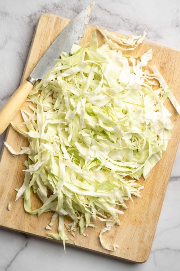 This Jamaican steamed cabbage recipe uses simple cooking methods and simple ingredients to infuse veggies with sweet, savoury island flavour. Chopped cabbage on a cutting board.