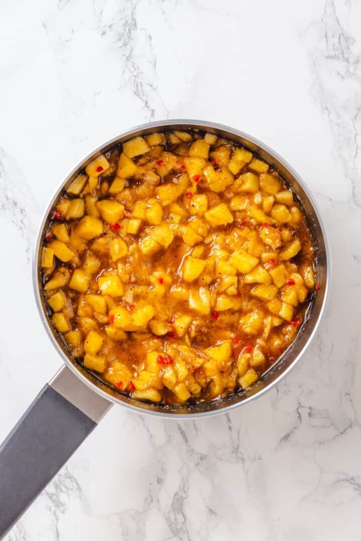 Sweet, savoury, and just a little spicy, this smooth, chunky mango chutney marries traditional Jamaican and Indian flavours beautifully. Mango chutney cooking away in a pot.