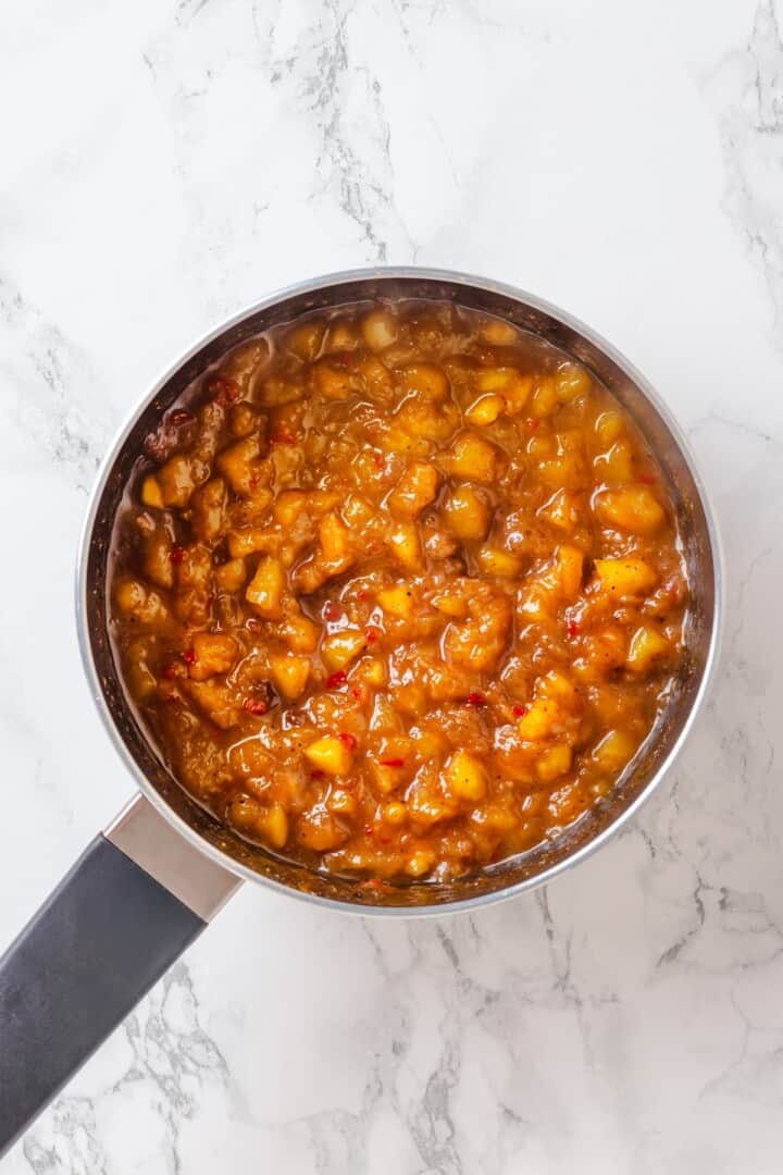 Sweet, savoury, and just a little spicy, this smooth, chunky mango chutney marries traditional Jamaican and Indian flavours beautifully. Well-simmered mango chutney in a pot.