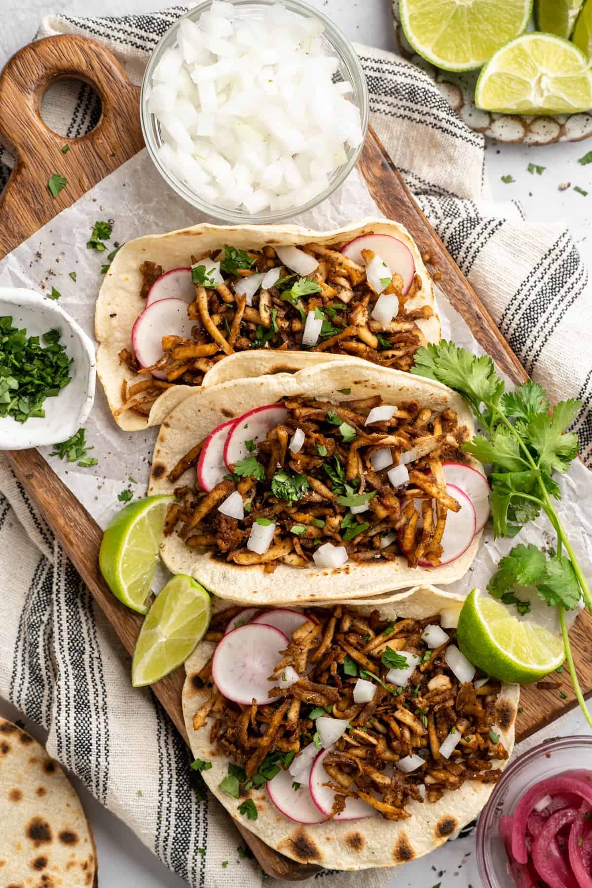 This shredded tofu is tossed in a savoury sauce and baked to crispy golden brown. It's the perfect protein addition to any vegan meal. Shredded tofu tocos with all the fixings.