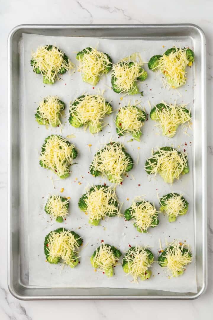 Cheesy vegan smashed broccoli is the perfect way to mix up your veggie routine. Served with a creamy garlic sauce, it's sure to impress. Seasoned broccoli florets sprinkled with vegan cheese.