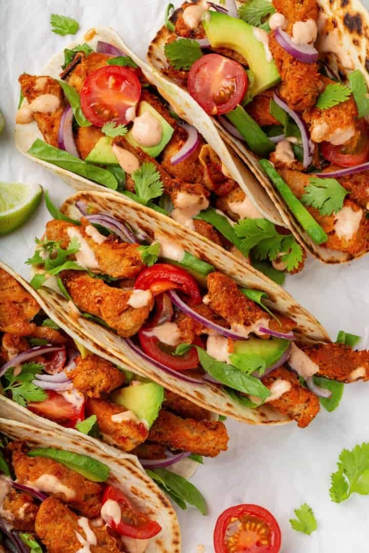 These vegan soy curl tacos pair perfectly crispy soy curl "chicken" with classic taco toppings and the BEST tangy, creamy lime sauce. Colourful vegan chicken tacos made with soy curls.