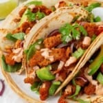 Close-up of three soy curl tacos on a plate.