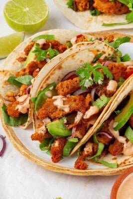 Close-up of three soy curl tacos on a plate.
