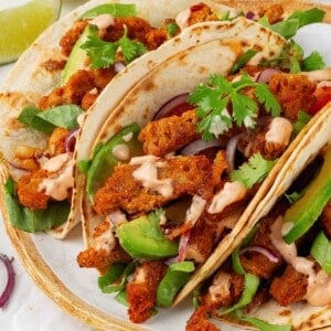 Close-up of three soy curl tacos on a plate.