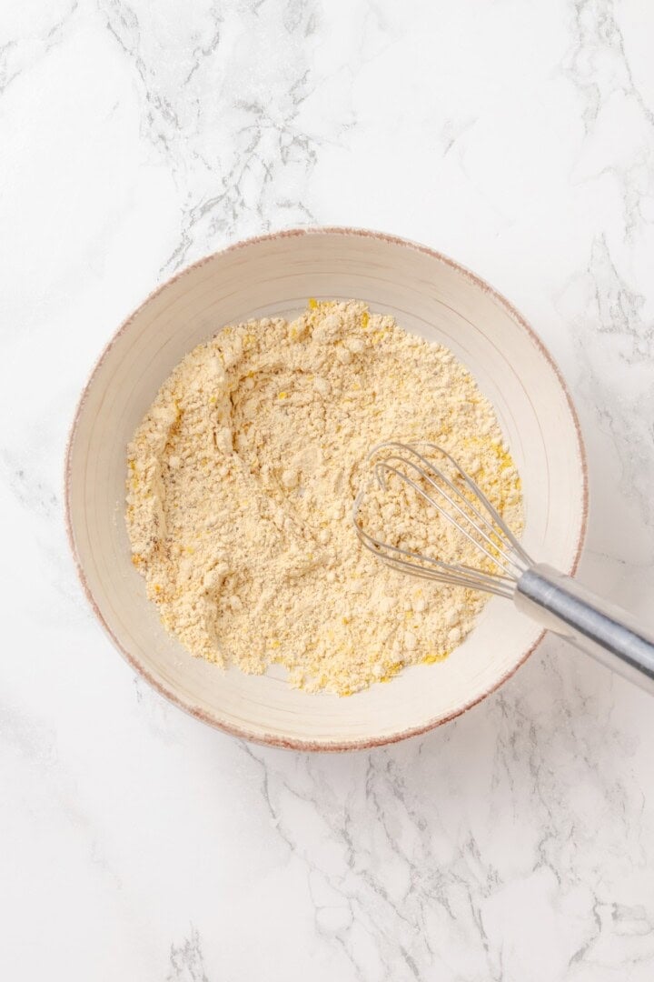 Start today right with this vegan omelette! Chickpea flour and water combine to make a tender omelette filled with veggies and vegan cheese. Whisking together chickpea flour, nutritional yeast, and seasonings in a bowl.