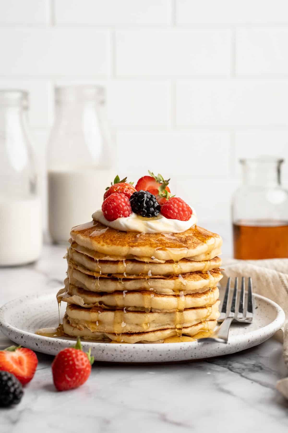 Easy to make and SO light and fluffy, these vegan cottage cheese pancakes are about to become your go-to, protein-packed breakfast. A stack of vegan cottage cheese pancakes on a plate.