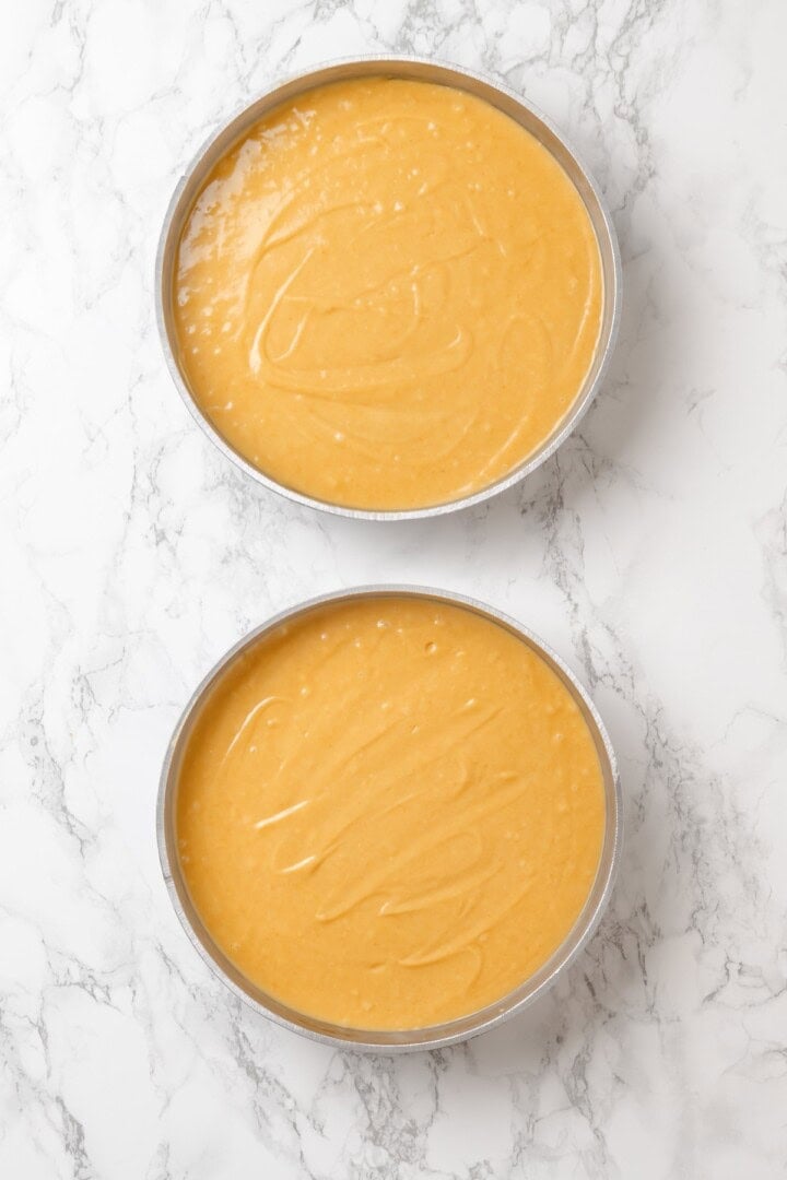 This vegan yellow cake is made of two layers of moist, tender, golden-yellow cake, filled and frosted with silky chocolate buttercream. Vegan yellow cake batter divided between two round cake pans.