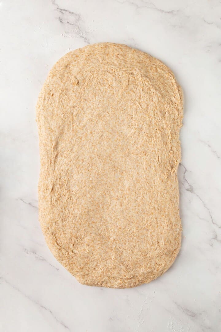 Looking for the perfect slice to build your PB&J or avocado toast on? This soft, tender whole grain sandwich bread is for you. Whole grain bread dough spread into a rectangle.