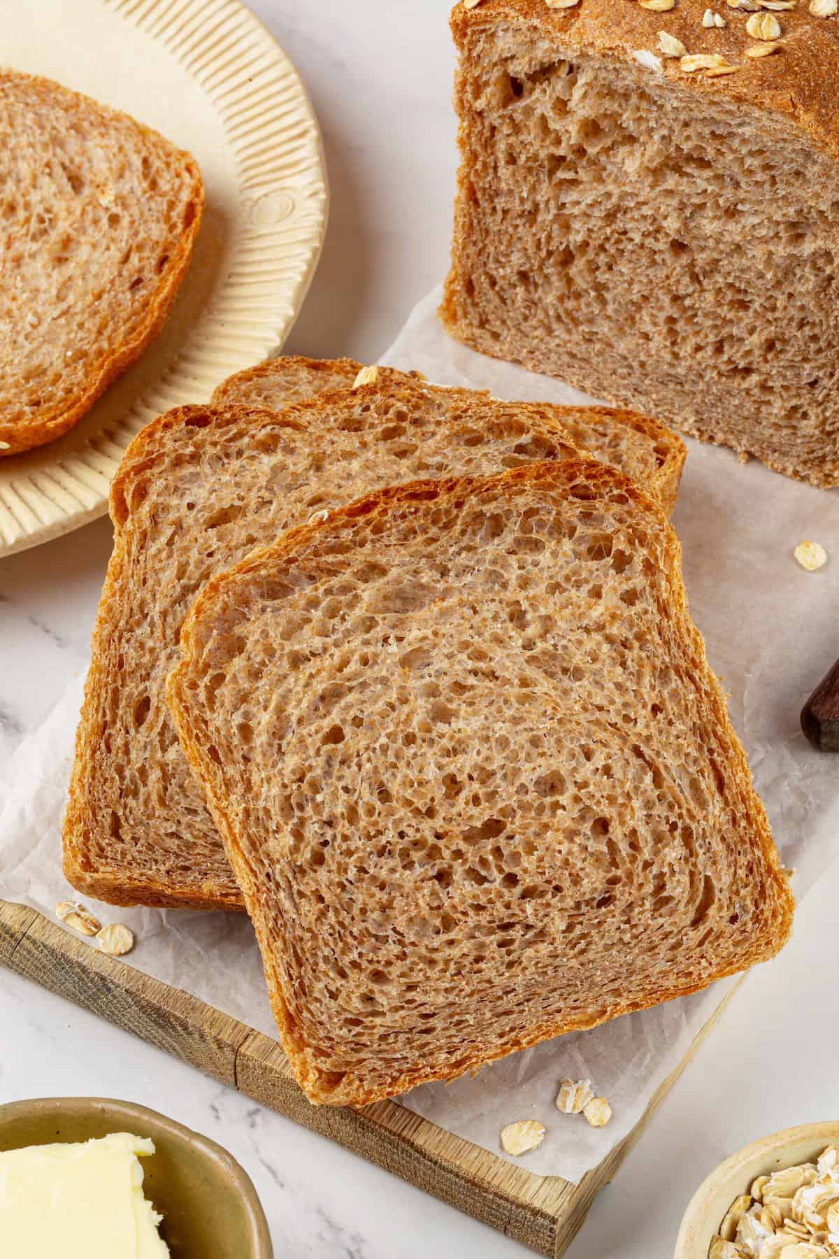 Looking for the perfect slice to build your PB&J or avocado toast on? This soft, tender whole grain sandwich bread is for you. Overhead image of two slices of homemade bread.